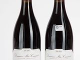 deux bouteilles de vin rouge posées l'une à côté de l'autre sur une surface blanche