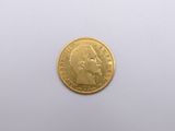 a close up of a gold coin on a white surface