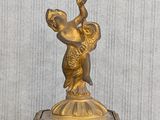 a gold clock with a statue on top of it