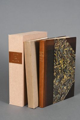 two books sitting on top of each other on a gray surface