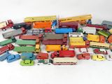 a pile of toy cars and trucks on a white surface