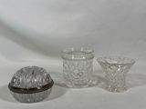 trois objets en verre posés sur une surface blanche