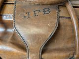 a close up of a brown leather bag with a handle
