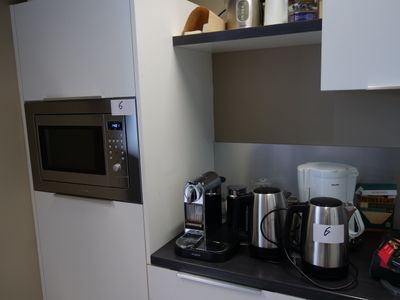 une cuisine équipée d'un micro-ondes, d'une cafetière et d'autres appareils électroménagers