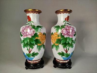 deux vases avec des fleurs peintes dessus, posés sur une table