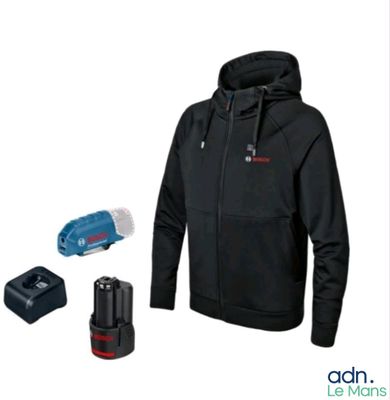 Cet homme porte un sweat à capuche noir et tient un outil sans fil.
