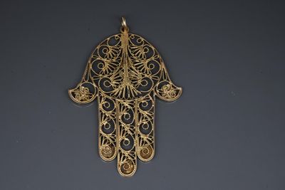 a close up of a gold hamsa hand hanging on a wall