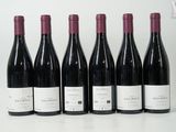 six bouteilles de vin sont alignées sur une table