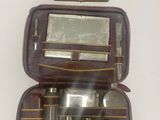 une trousse marron contenant un miroir et une paire de ciseaux