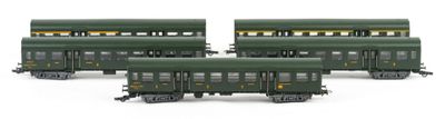 three green train cars sitting next to each other on a white surface