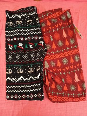 deux paires de leggings posées sur un lit recouvert d'une couverture rose