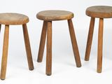 three wooden stools sitting next to each other on a white surface