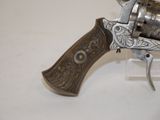 an old revolver with a wooden handle on a white surface