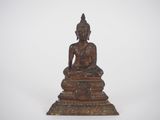 statue of a seated buddha on a pedestal on a white background