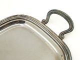 a silver tray with a handle on a white surface