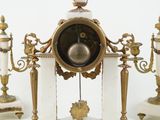a white and gold clock sitting on top of a table