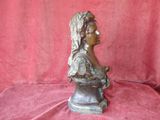 bronze bust of a woman with a flower in her hair