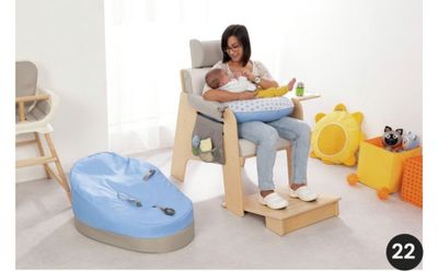 une femme assise sur une chaise haute, un bébé sur les genoux