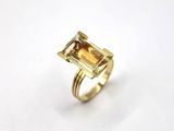 un gros plan d'une bague en or sertie d'une tourmaline verte