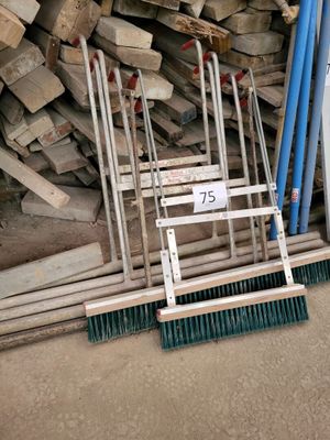 a pile of wood and a broom in the middle of the floor