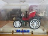 une petite maquette de calèche exposée dans une vitrine