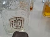 a bottle of alcohol sitting on a table next to a cell phone