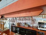 many wine glasses hanging from the ceiling above the bar