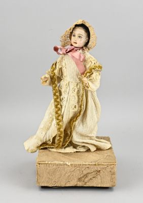 an antique doll of a woman in a white dress and bonnet holding a rose