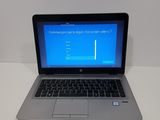 a laptop computer sitting on a table with a blue screen