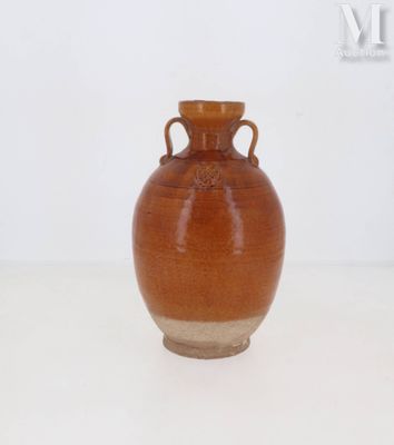 un vase brun posé sur une table à fond blanc