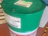 a green barrel sitting on the floor next to a pallet