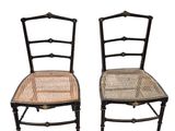 une paire de chaises peintes en noir avec des assises en osier