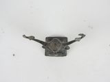 a small metal object on a white surface with a white background