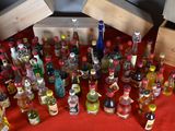 many bottles of alcohol on a table with a red table cloth