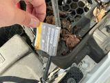 a person holding a credit card in front of a car ' s engine