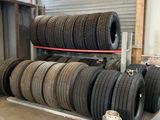de nombreux pneus empilés sur un support dans un garage