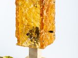 a yellow lamp that is on top of a wooden stand