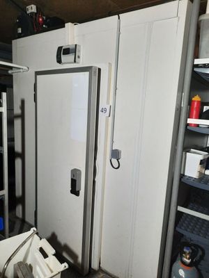 une photo d'un réfrigérateur dans une pièce très encombrée