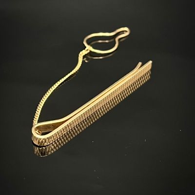 un peigne doré et une paire de ciseaux posés sur une surface noire