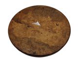 a round wooden table with a small piece of wood on it