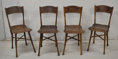 three wooden chairs sitting next to each other on a cement floor