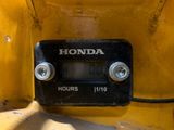 a close up of a clock on the back of a yellow truck