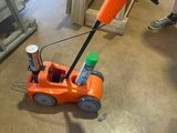 an orange toy car that is sitting on the floor