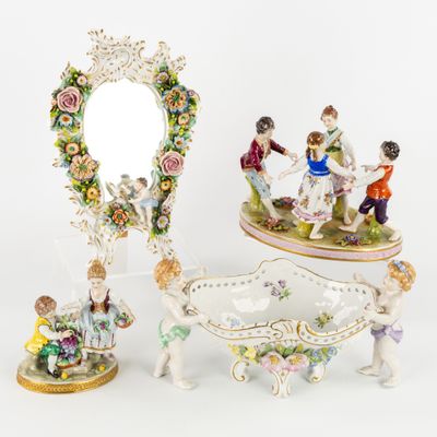 three porcelain figurines of people and a mirror on a table