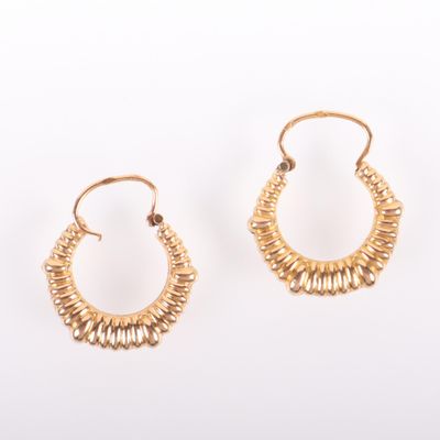 une paire de boucles d'oreilles en or sur fond blanc