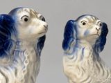 two blue and white dog figurines sitting next to each other