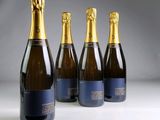 four bottles of champagne are lined up on a table