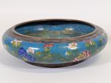 a blue bowl with flowers on it sitting on a table