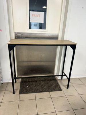 une petite table sur laquelle est posée une pancarte, dans une pièce
