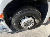 a white truck with a flat tire parked on the side of the road